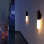 Motion-activated LED lamp illuminating a dark hallway with bright white light.