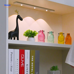 Wireless motion sensor lamp mounted on bookshelf providing automatic ambient lighting.