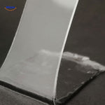 Clear NanoGrip double-sided tape showing strong adhesive strength.
