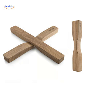 Oak wooden trivet with modern cross-shaped design and natural wood grain.
