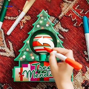 Close-up of electric painting pen decorating a wooden ornament with detailed artwork.