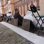 Padded travel prayer mat in use during group prayer inside a mosque.