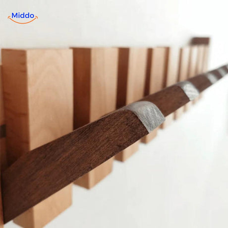 Detailed view of handmade wooden piano coat rack's construction and hooks.