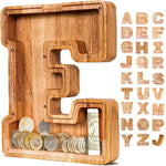 Child inserting coins and bills into wooden letter piggy bank, learning to save money.
