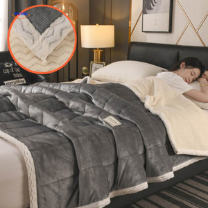 Grey and white combination wool blanket folded on bed.