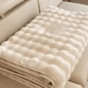 Beige plush furniture cover neatly folded for compact storage and easy transport.