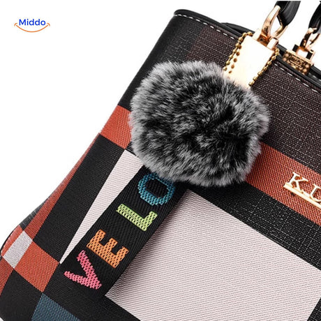 Decorative pom-pom detail on striped tote bag design.