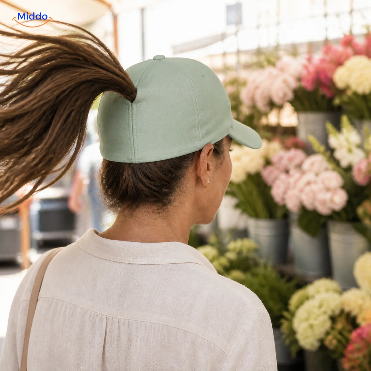 Woman with dark-brown hair wears a mint Ponylite cap at a flower market