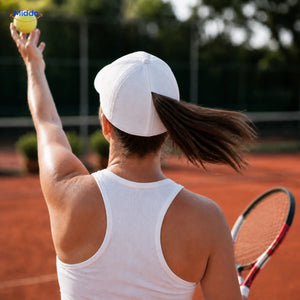 Woman with brown hair wears a white Ponylite cap with magnetic seam while playing tennis