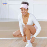 Pink ponytail cap styled on woman with short curls in sporty outfit.