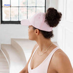 Pink ponytail cap with hair opening styled for high bun hairstyles.