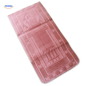 Portable padded travel prayer mat in soft pink, folded and ready for travel.