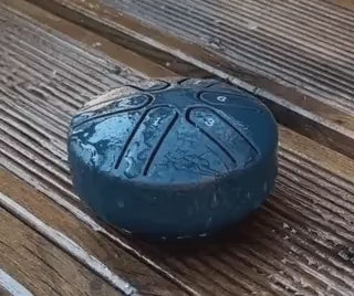 Steel tongue drum tested in rain demonstrating weather-resistant design.