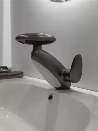 Dark gray pull-out LED bathroom faucet mounted on a countertop in a stylish bathroom setting.