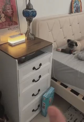 Sleep aid speaker on nightstand emitting warm glow light for peaceful bedroom environment
