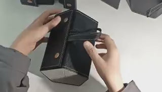 Hands demonstrating the fold-open mechanism of a black 6-slot multi-compartment eyeglasses case.