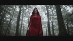 Red velvet Spookora cape worn outdoors in forest setting for Halloween atmosphere.