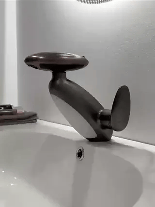 Dark gray pull-out LED bathroom faucet mounted on a countertop in a stylish bathroom setting.