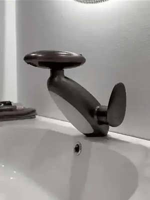 Dark gray pull-out LED bathroom faucet mounted on a countertop in a stylish bathroom setting.