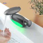 Pull-out LED faucet with green temperature-indicator light glowing during water flow.
