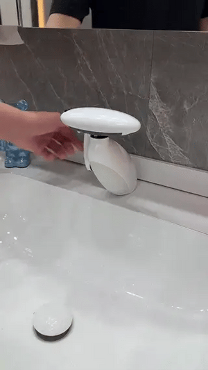 White pull-out LED bathroom faucet installed on a countertop vanity in a modern bathroom.