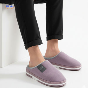 Man relaxing while wearing soft purple non-slip slippers.