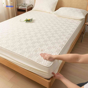 Quilted mattress protector with anti-slip design and cushioned protective layer.