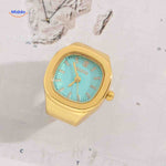 Gold ring watch with mint green square dial.