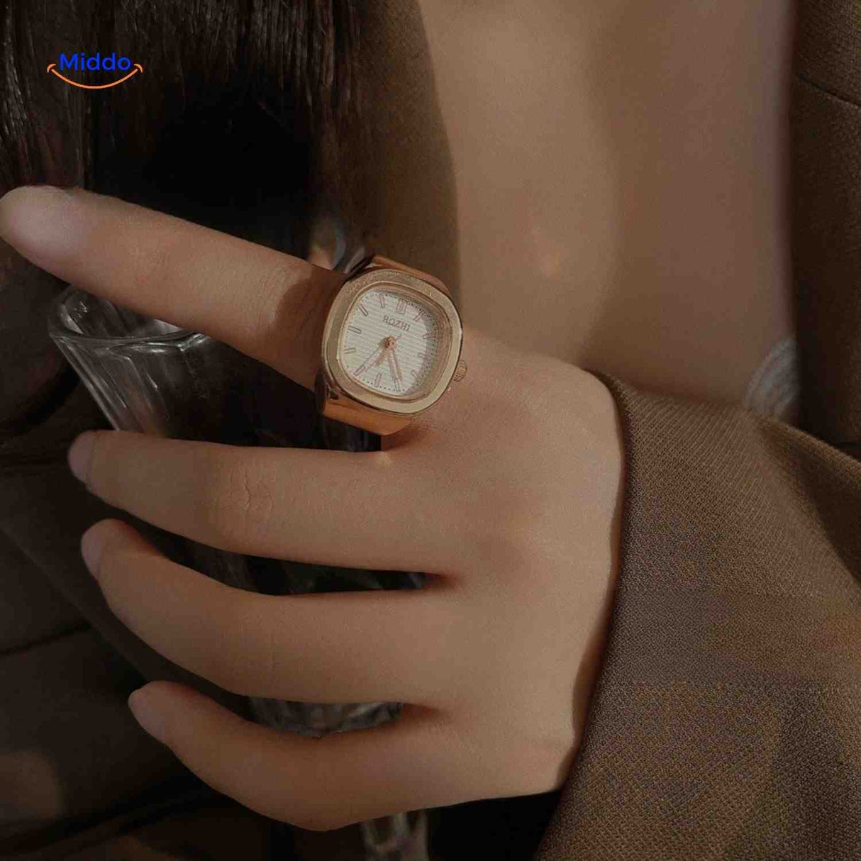 Rose gold ring watch with white square dial on hand.