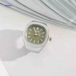 Silver ring watch with green square dial.