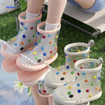 Shark rain boots on outdoor terrain with muddy ground, ideal for kids' playtime.