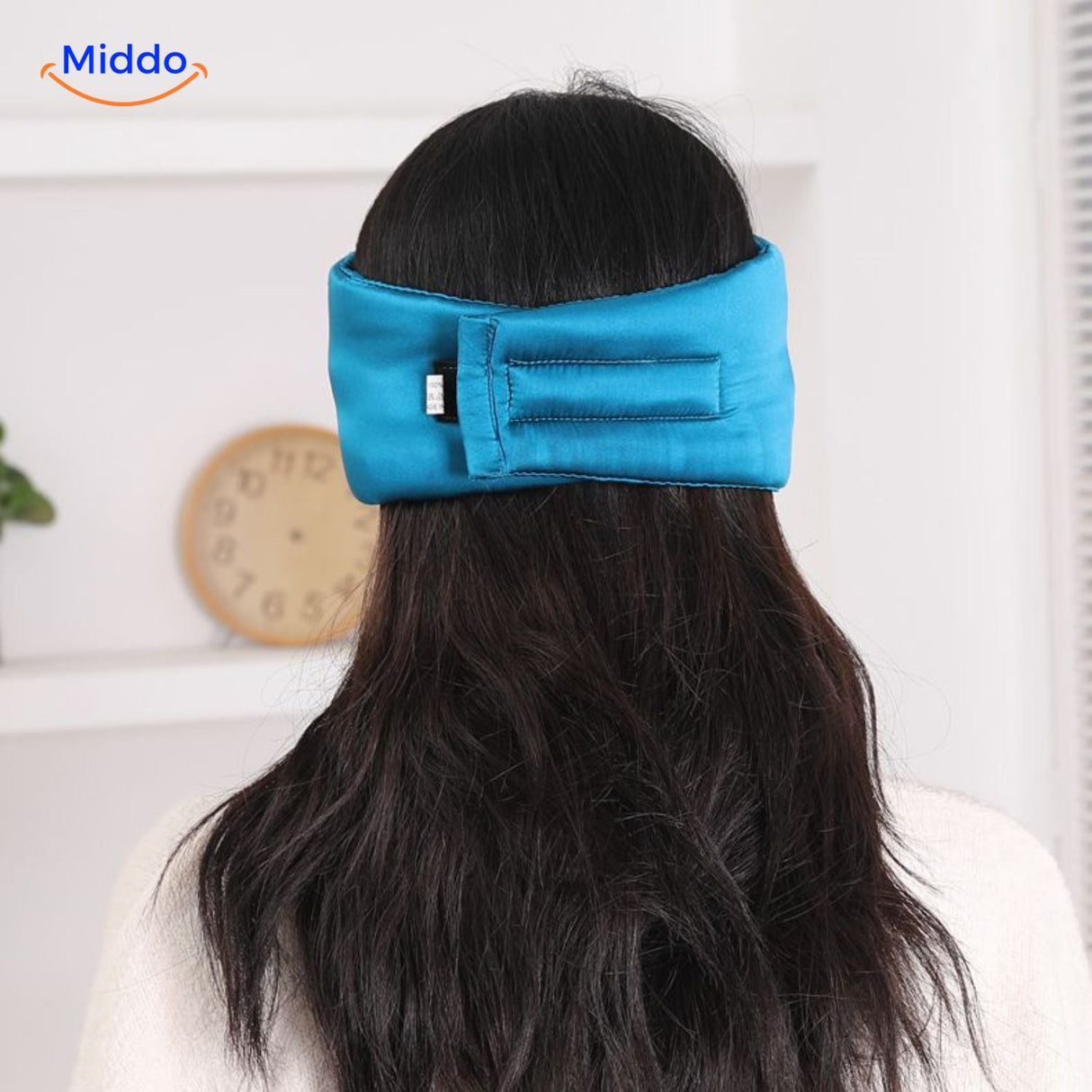 Person wearing blue silk sleep mask showing the secure fit and complete darkness benefit.