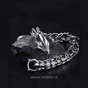 Silver dragon bracelet laid on a black stone surface for a dramatic, editorial look.