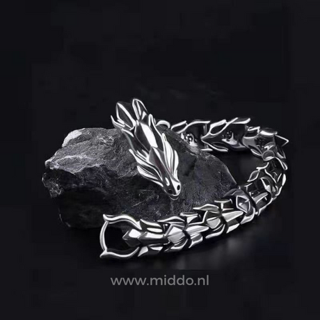 Silver dragon bracelet laid on a black stone surface for a dramatic, editorial look.