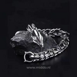 Silver dragon bracelet laid on a black stone surface for a dramatic, editorial look.