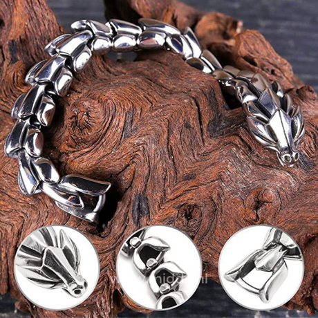 Close-up of silver dragon bracelet resting on a wooden surface, revealing intricate scale texture.