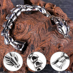 Close-up of silver dragon bracelet resting on a wooden surface, revealing intricate scale texture.