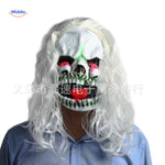 Monstrous skull mask with bulging eyes and white curly hair.