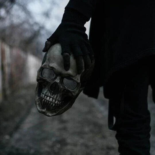 Hand holding the realistic skull mask to show size and lightweight design.
