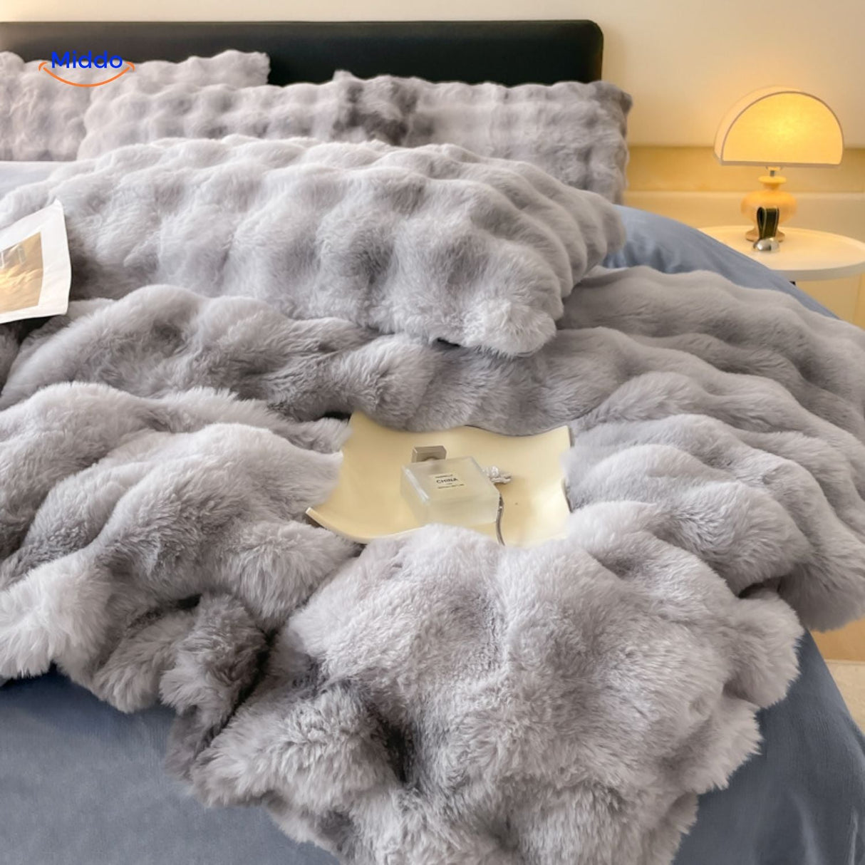 Gray plush duvet cover with table lamp bedroom styling.