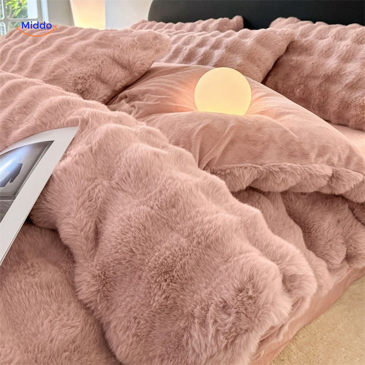 Pink plush rabbit fur duvet with matching pillows and bedside light.