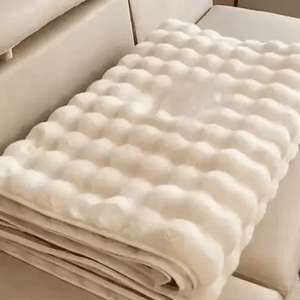 Beige plush furniture cover neatly folded for compact storage and easy transport.