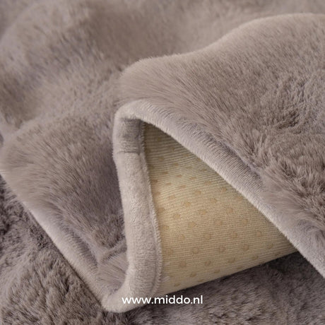 Non-slip backing detail on gray furniture cover prevents shifting and keeps cover secure.