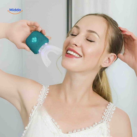 Green sonic electric toothbrush in use with blue light whitening function activated.