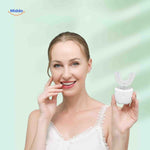 Woman smiling while using U-shaped sonic electric toothbrush with whitening effects.