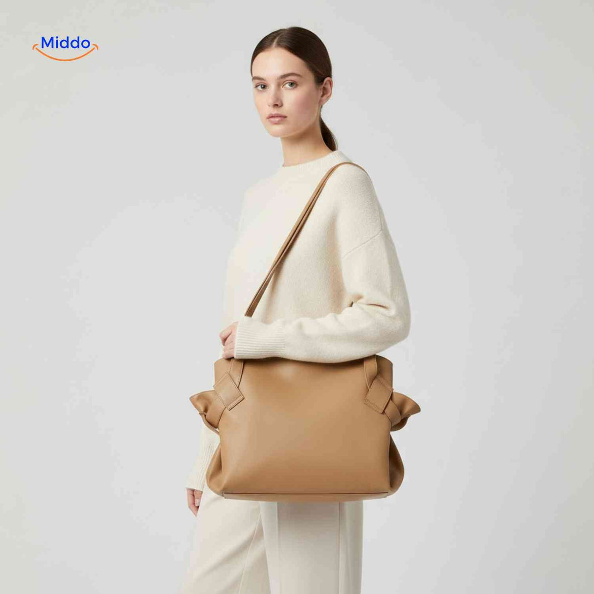 Spacious foldable leather shoulder bag featuring decorative bow detail.