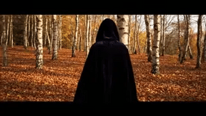 Black velvet Spookora cape in wooded forest setting creating spooky Halloween mood.