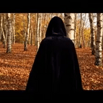 Black velvet Spookora cape in wooded forest setting creating spooky Halloween mood.