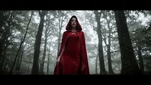 Red velvet Spookora cape worn outdoors in forest setting for Halloween atmosphere.