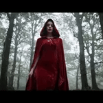 Red velvet Spookora cape worn outdoors in forest setting for Halloween atmosphere.